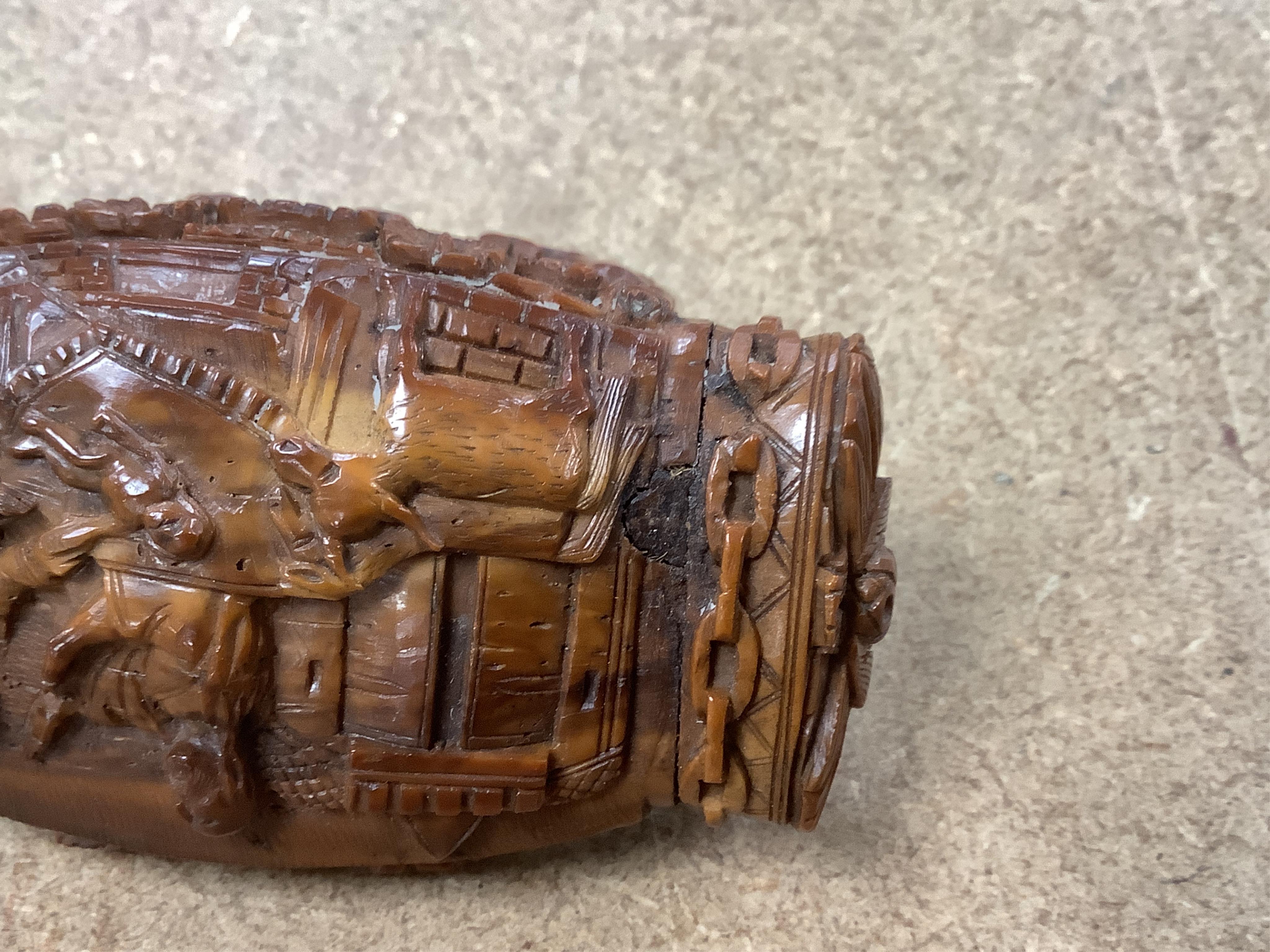 An 18th / 19th century European carved figural coquilla nut snuff box, 8.5cm wide
